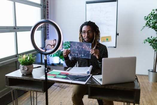 A financial vlogger in a home studio discusses cryptocurrency trends using charts and a laptop.