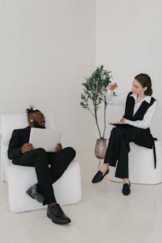 Diverse adults engaging in a productive business meeting with digital devices indoors.