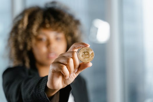 Focused young woman holding a Bitcoin coin indoors close-up, symbolizing cryptocurrency.