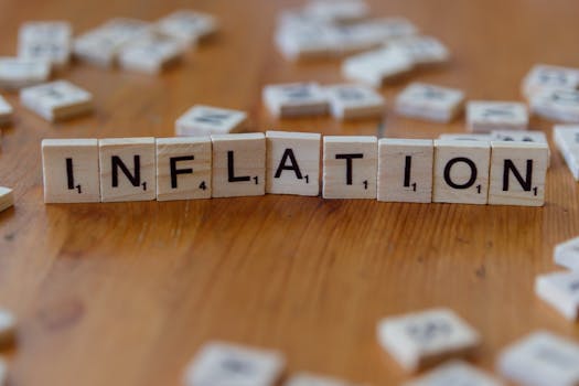 Scrabble letter tiles spelling 'INFLATION' on a wooden table, signifying economic concepts.