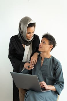 Young couple collaborating indoors with a laptop, depicting teamwork and modern technology.